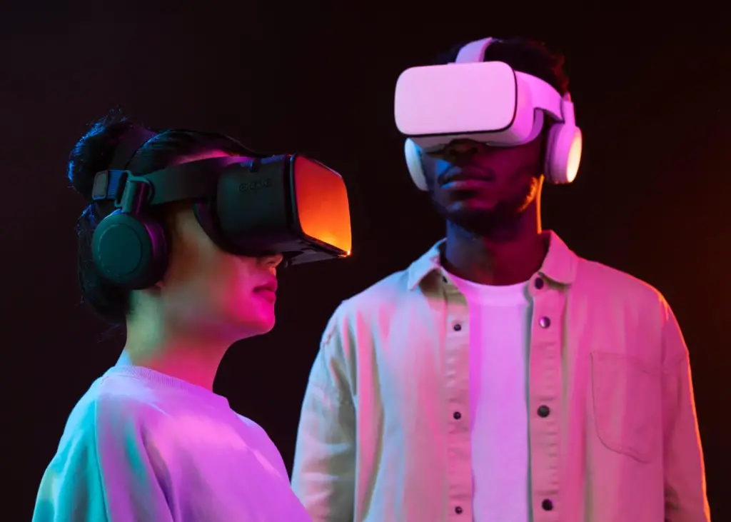 Duas pessoas usando headsets de realidade virtual em ambiente iluminado.