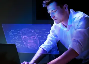 Homem analisando projeção digital com rosto estilizado, representando IA.