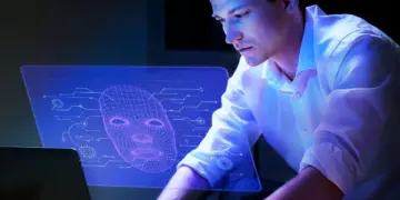 DeepSeek AI: O que é e por que tem Preocupado Concorrentes do Setor de TI? 5 Homem analisando projeção digital com rosto estilizado, representando IA.