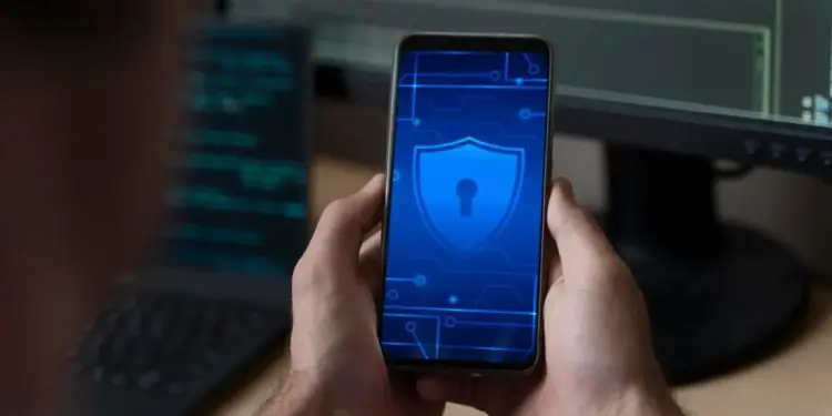 Celular com ícone de segurança digital na tela, representando aplicativos de segurança digital.