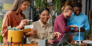 10 Melhores Franquias de Tecnologia para Investir em 2025 16 Grupo em ambiente sustentável pesquisa franquias de tecnologia em laptop e celular.