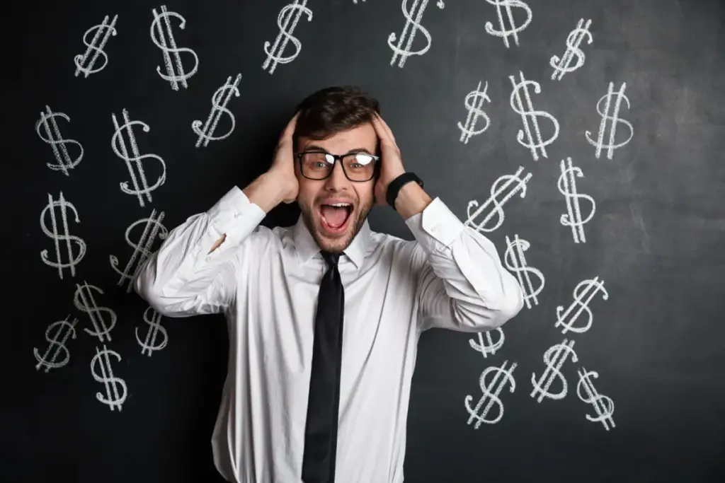 Homem com as mãos na cabeça à frente de uma quadro negro onde existem cifrões desenhados, representando golpes financeiros.