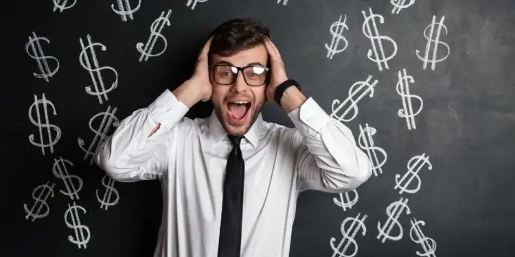 Homem com as mãos na cabeça à frente de uma quadro negro onde existem cifrões desenhados, representando golpes financeiros.