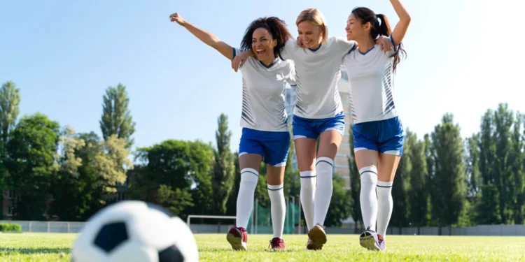 9 Regras de futebol pouco conhecidas e o impacto no jogos 18 Jogadoras comemoram um gol em campo, destacando o impacto das regras de futebol.