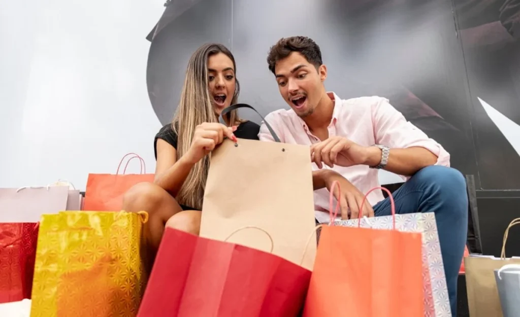 Casal confere pacotes das últimas compras feitas, representando táticas de vendas.