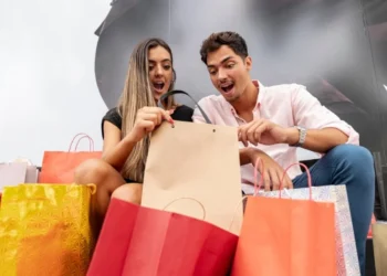 Casal confere pacotes das últimas compras feitas, representando táticas de vendas.