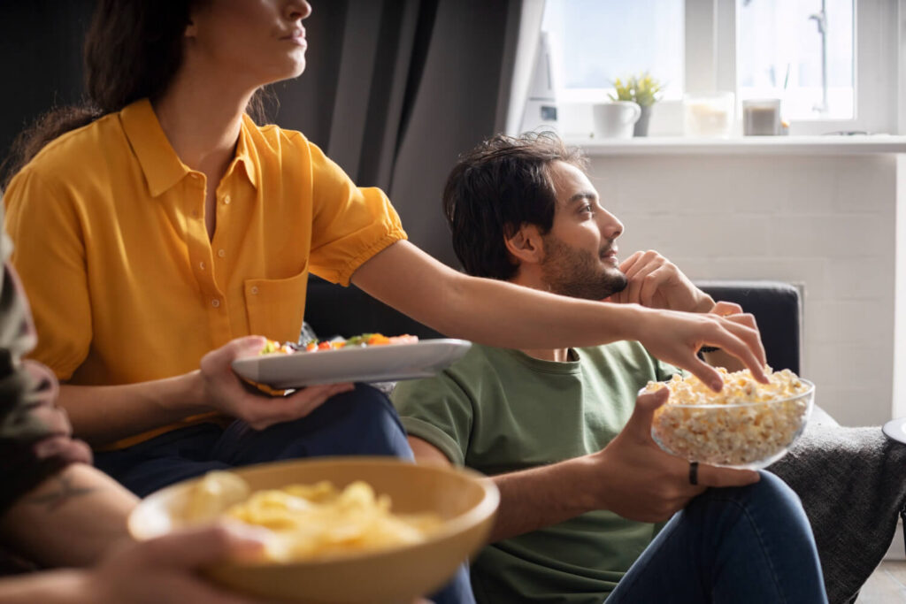 Grupo de amigos assistindo a filmes e séries no Paramount+ enquanto compartilham petiscos.