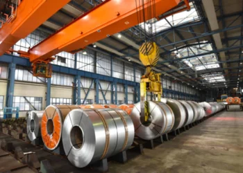 Galpão de siderúrgica com rolos de material acabado expostos. Fica no Brasil.