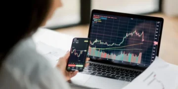 Day trade com criptomoedas: um passo a passo para lucrar muito 5 Mulher analisa flutuações do mercado para realizar day trade com criptomoedas.
