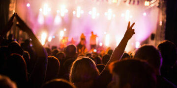 Festivais 2025: Explore os principais eventos musicais e culturais do ano  18 Público animado em show noturno com luzes vibrantes, representando a energia dos festivais 2025