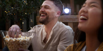 Amigos se divertem assistindo novas séries de 2025 em uma sessão de cinema ao ar livre.