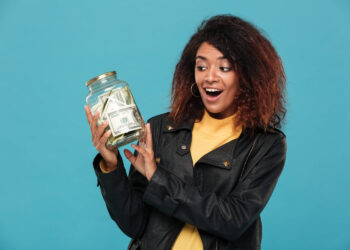 Mulher segurando um pote cheio de dinheiro, simbolizando a possibilidade de gerar renda extra em 2025.