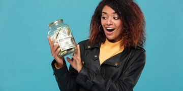 Mulher segurando um pote cheio de dinheiro, simbolizando a possibilidade de gerar renda extra em 2025.