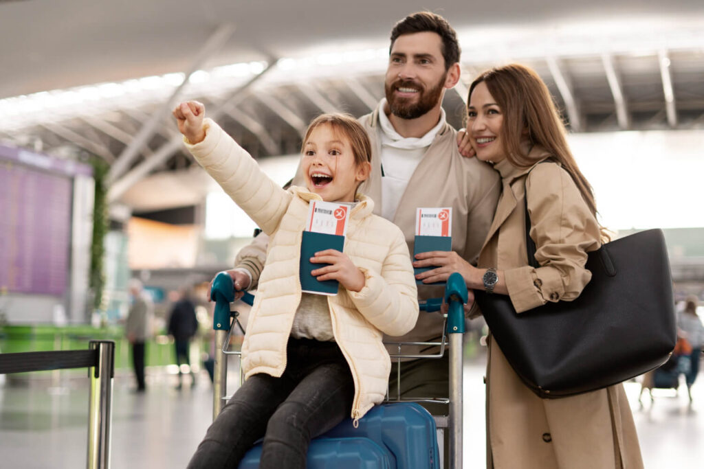 Família feliz no aeroporto com passagens, mostrando que milhas valem dinheiro e rendem viagens.