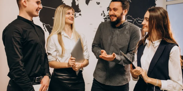 Trabalhar no Exterior sem sair do Brasil: 6 Estratégias que estão em alta 18 Grupo de profissionais discutindo em um ambiente corporativo, planejando como trabalhar no exterior.