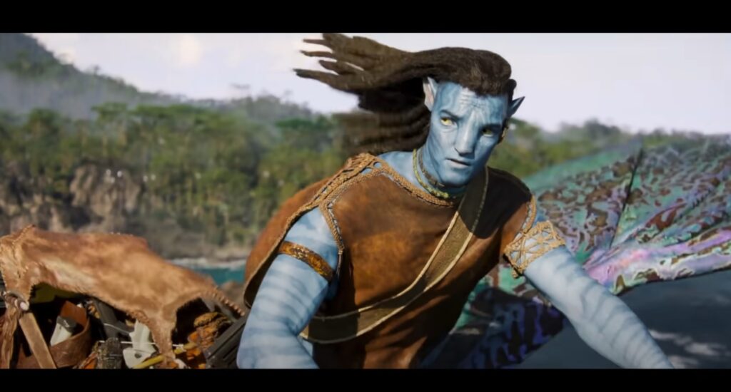 Avatar 3: Personagem masculino com pele azul e trajes tribais, observando o horizonte em ambiente natural.