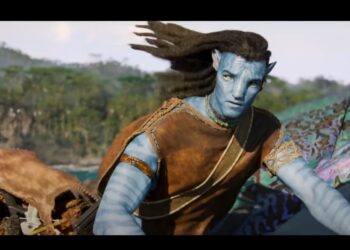 Avatar 3: Personagem masculino com pele azul e trajes tribais, observando o horizonte em ambiente natural.