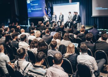 Grupo de pessoas debatendo sobre investimento em franquias em um fórum internacional