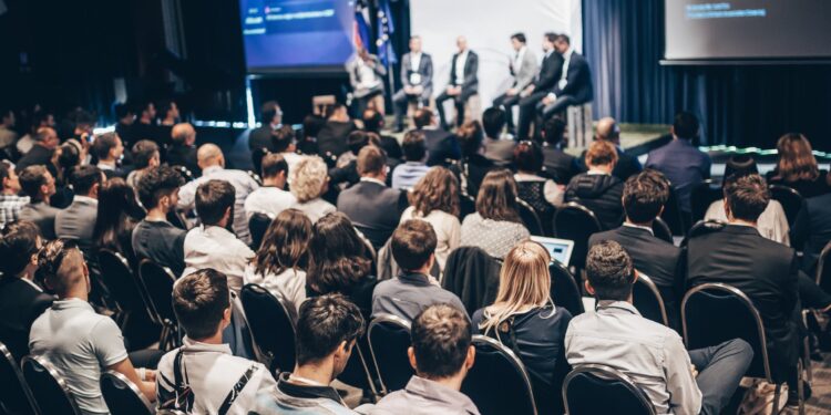 Grupo de pessoas debatendo sobre investimento em franquias em um fórum internacional
