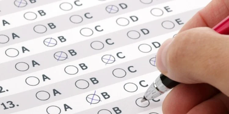 Pessoa preenchendo cartão-resposta de concurso público. Representando "como passar em um concurso público?"