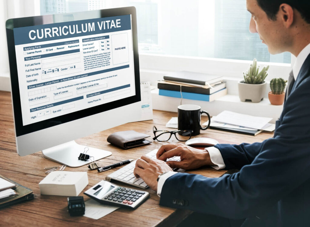 Homem em escritório preenchendo formulário de currículo para vagas temporárias.