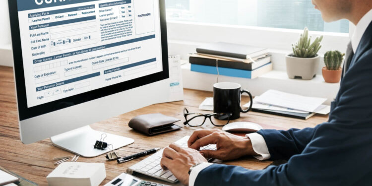 Vagas Temporárias: Como Garantir uma Renda Extra em 2025? 18 Homem em escritório preenchendo formulário de currículo para vagas temporárias.