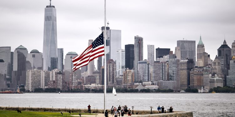 An amazing shot of the US flag in a park on the Manhattan skyline background