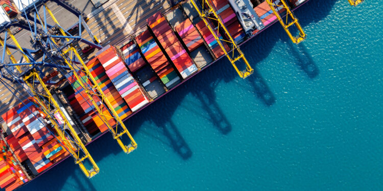 Mercados globais recuam após anúncio de novas tarifas por Trump 14 Aerial view of cargo ship and cargo container in harbor.
